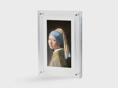 a glass frame with a painting of a girl with a pearl earring on it