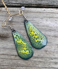 Crackle enamel on copper. Teal, green, and yellow enamel used. Earring hooks are silver plated. Artsy Green Patina Jewelry, Artistic Yellow Teardrop Jewelry, Green Teardrop Metal Earrings, Artsy Green Metal Jewelry, Green Artisan Enamel Earrings, Artisan Green Enamel Earrings, Bohemian Green Enamel Earrings, Unique Green Teardrop Earrings, Unique Green Drop Jewelry