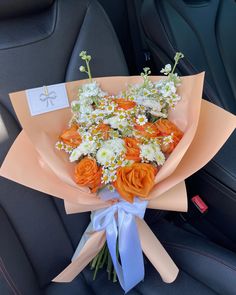 an orange and white bouquet sitting in the back seat of a car