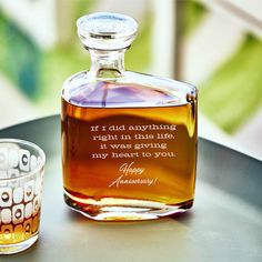 a bottle of alcohol sitting on top of a table next to a shot glass filled with liquid