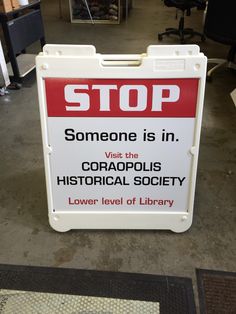 a red and white sign that says stop someone is in