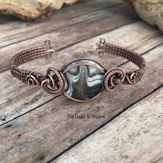 This beautiful stone of Zebra Calcite, aka Phantom Calcite, is wrapped in oxidized copper wire. This cuff bracelet is flexible enough to give a gentle squeeze for a snug fit. Over time the copper will become hardened creating a custom fit bracelet. ZEBRA CALCITE, also known as PHANTOM CALCITE, can help you to connect with your spiritual side. It is a very calming and relaxing crystal, and it can help you to let go of your worries and concerns. It is also a good choice for people who want to redu Artisan Wire Wrapped Adjustable Bracelets, Unique Copper Wire Cuff Bracelet Gift, Wire Wrapped Copper Wire Cuff Bracelet Gift, Artisan Adjustable Wire Wrapped Cuff Bracelet, Artisan Wire Wrapped Cuff Bracelet Gift, Unique Copper Wire Wrapped Cuff Bracelet, Zebra Calcite, Oxidized Copper, Fitness Bracelet