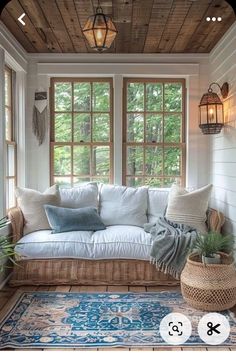 a living room filled with lots of furniture and pillows on top of a blue rug