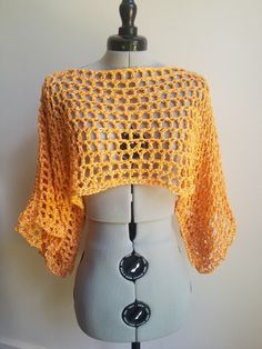 a white mannequin with a yellow crochet top on it