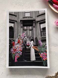 an old photo of a couple holding hands in front of a building with flowers on the steps