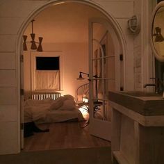 an archway leading into a bedroom with a bed and sink