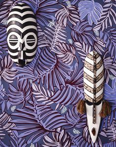 two african masks on a purple and blue wallpaper with palm fronds in the background