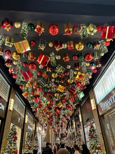 christmas decorations adorn the ceiling in this shopping mall