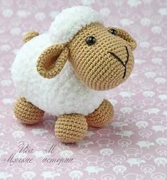 a crocheted stuffed sheep sitting on top of a pink background with the caption cute sheep free english pattern