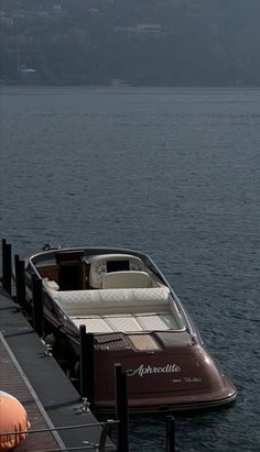 a boat is docked at the end of a pier with an inflatable mattress on it