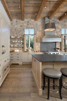 a large kitchen with an island and two stools