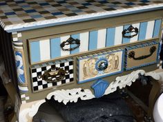 an old dresser has been decorated with blue and white checkered tiles on the drawers