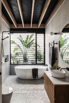 a large white bath tub sitting in a bathroom next to a sink and shower head