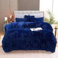 a blue comforter set on a bed in a room