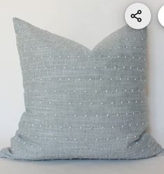 a gray pillow with white dots on it next to a black and white polka dot button