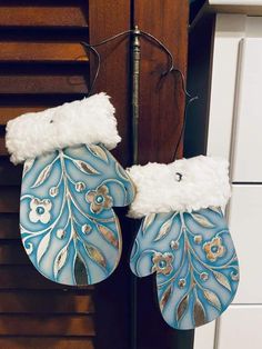 two blue and white mittens hanging from a hook