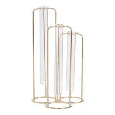 three glass tubes are in a metal stand on a white background, one is gold and the other is clear