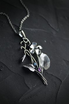 ITEM DESCRIPTION: The size H 5 cm x W 3 cm (2 x 1 1/3 inch). Weight - 3 g. You can buy it with a silver chain or without it. This spring flower is so delicate. So I was inspired by nature and made a wild violet flower of sterling silver, amethyst, and blue zircon. This is a very detailed handmade necklace. This floral jewelry will be a great addition to your jewelry collection or gift for someone whose you love. This handmade necklace will come to you in a gift box - ready for gifting. The parce Elegant Sterling Silver Necklace With Birth Flower, Nature-inspired Flower Charm Pendant Necklace, Silver Nature-inspired Necklace With Flower Charm, Nature-inspired Silver Flower Necklace With Charm, Silver Necklace With Nature-inspired Flower Charm, Sterling Silver Flower Pendant Jewelry, Unique Silver Flower Pendant Necklace, Unique Silver Necklace With Flower Pendant, Unique Flower Pendant Necklaces With Charm