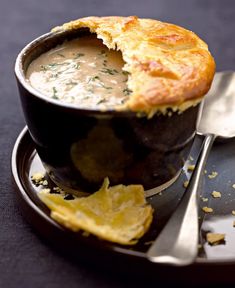 a bowl of soup and some chips on a plate