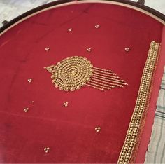 a red cushion with gold beading on it