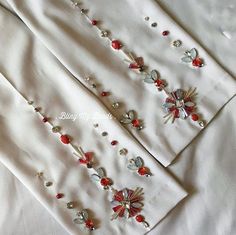 two white pants with red and silver beads on them