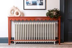 a radiator in the corner of a room with a painting on the wall