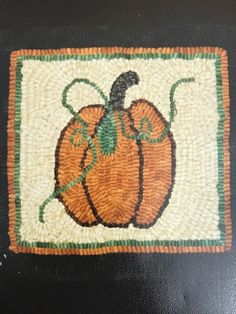 a close up of a rug with a pumpkin on it