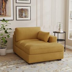 a living room with a yellow chair and pictures on the wall above it, along with a potted plant