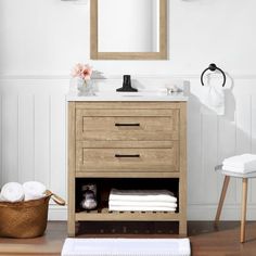 a bathroom with a sink, mirror and towels on the counter in front of it