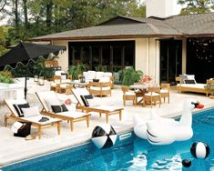 an outdoor pool with lounge chairs, umbrellas and inflatable ducks floating on the water