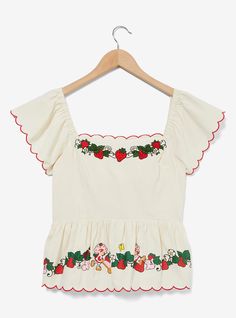 Sweeten up your look with this Strawberry Shortcake -inspired top! Featuring embroidered strawberries along the top  the bottom hem includes a printed design of Strawberry with the fruits. With ruffled sleeves and a tie-back closure  this blouse is perfect for picnics  parties  and beyond. A BoxLunch Exclusive! Strawberry Theme Outfit, Strawberry Inspired Outfit, Fruity Aesthetic, Strawberry Shortcake Shirt, Strawberry Shortcake Movie, Embroidered Strawberries, Vintage Strawberry