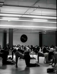 a group of people doing yoga in a large room