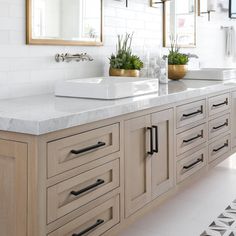 a large bathroom with two sinks and mirrors on the wall next to it's countertop