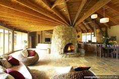 a living room filled with lots of furniture and a fire place in the middle of it