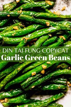 some green beans are on a white plate with the words din taifung copycat garlic