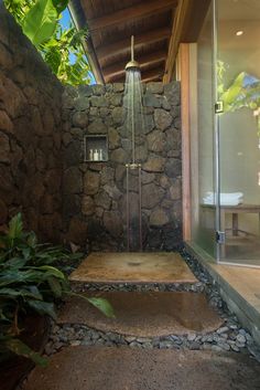 an outdoor shower in the middle of a stone wall and steps leading up to it