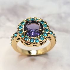 Simulated Stones Plated/Filled Alloy Base Size 8 Purple Blue Gold Gold Tone Simulated Gemstone Halo Ring Gold Amethyst Ring With Gemstone Accents, Purple Jeweled Round Jewelry, Gold Amethyst Jewelry With Accent Stones, Purple Round Multi-stone Jewelry, Blue Amethyst Elegant Ring, Blue Amethyst Ring Elegant Style, Elegant Blue Amethyst Ring, Purple Multi-stone Round Jewelry, Purple Multi-stone Amethyst Crystal Ring