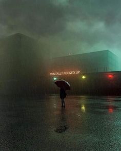 a person walking in the rain with an umbrella and red traffic lights behind them on a rainy day