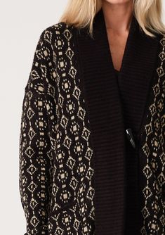 An ultra-warm mid-length cardigan in a black and taupe geo jacquard design. Geo jacquard Relaxed fit Long sleeve Drop shoulder Mid-length Shawl collar Toggle button closure Side pockets Contrast ribbed trim Bohemian cardigan An effortless slouchy cardigan designed in a cool geo jacquard pattern. Featuring a warm shawl collar, essential side pockets, and long sleeves with a relaxed dropped shoulder. The toggle closure secures at the front. Model is 5'9, wearing a size S/M. Style: I-50249K-SMG Fall Jacquard Knit Cardigan For Layering, Beige Jacquard Knit Long Sleeve Outerwear, Black Jacquard Knit Long Sleeve Outerwear, Black Jacquard Knit Outerwear For Fall, Elegant Jacquard Knit Cardigan For Winter, Fall Workwear Jacquard Knit Cardigan, Fall Jacquard Knit Cardigan For Work, Black Jacquard Knit Cardigan For Fall, Black Fair Isle Cardigan For Fall