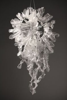 a chandelier hanging from the ceiling in front of a black background with white flowers