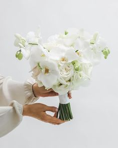 a woman holding a bouquet of white flowers