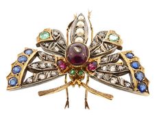 "A stunning Victorian butterfly brooch worked in 14K yellow gold and silver. The body comprises a cabochon garnet inset with a rose cut diamond, all set between a pair of bright green emerald eyes and a tapering tail of natural pearls The delicately pierced wings are set with 24 rose cut diamonds, two rubies, two emeralds and eight blue sapphires. The butterfly is completed with gold legs and antennae. The brooch is beautifully made. Tested and guaranteed 14K gold. * Origin: America, ca. 1880. * Elegant Butterfly Brooch For Collectors, Elegant Collectible Butterfly Brooches, Elegant Butterfly Brooches For Collectors, Elegant Butterfly Brooch, Luxury Jeweled Brooches As Gift, Luxury Jeweled Brooches For Gift, Victorian Butterfly, Emerald Eyes, Diamond Butterfly