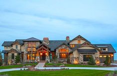 a large house with lots of windows and lights on it's front lawn area