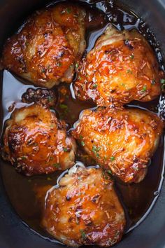 chicken thighs in a slow cooker being cooked