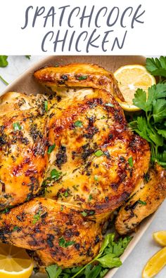 a close up of a chicken on a platter with lemons and parsley