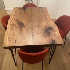 a wooden table with red chairs around it