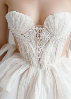 the back of a woman's wedding dress with beading on her bustle