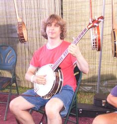 a man sitting in a chair while playing a guitar