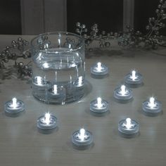 many small candles are lit on a table