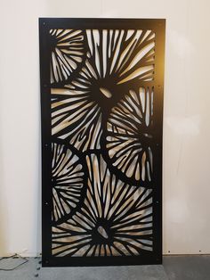 an intricate metal screen is displayed against a white wall